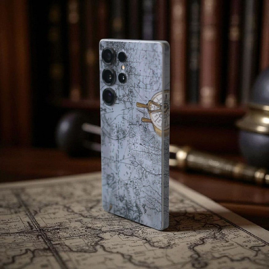 Phone case with map design mobile skin on a surface with books and globe in the background