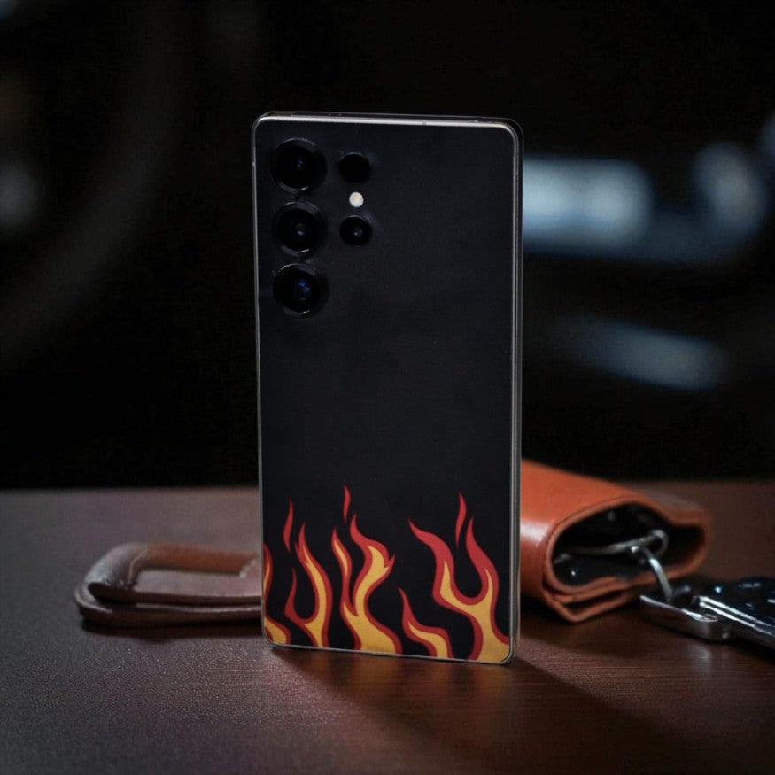 Smartphone with black fire mobile skin on a dark surface
