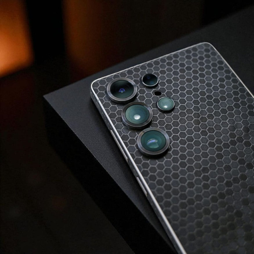 Smartphone with black honeycomb mobile skin on a dark surface