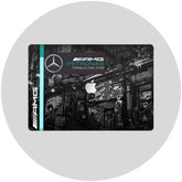 Round white laptop with a Mercedes-AMG skin and Apple product display on a black and white background.