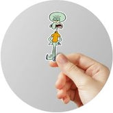 Hand holding a small cartoon character with a round gray background